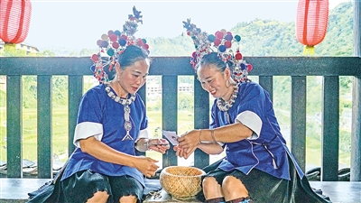     程陽橋上，侗族婦女在展示制作侗族刺繡產品。繡品圖案精美、色彩艷麗，成為當?shù)靥厣a業(yè)。